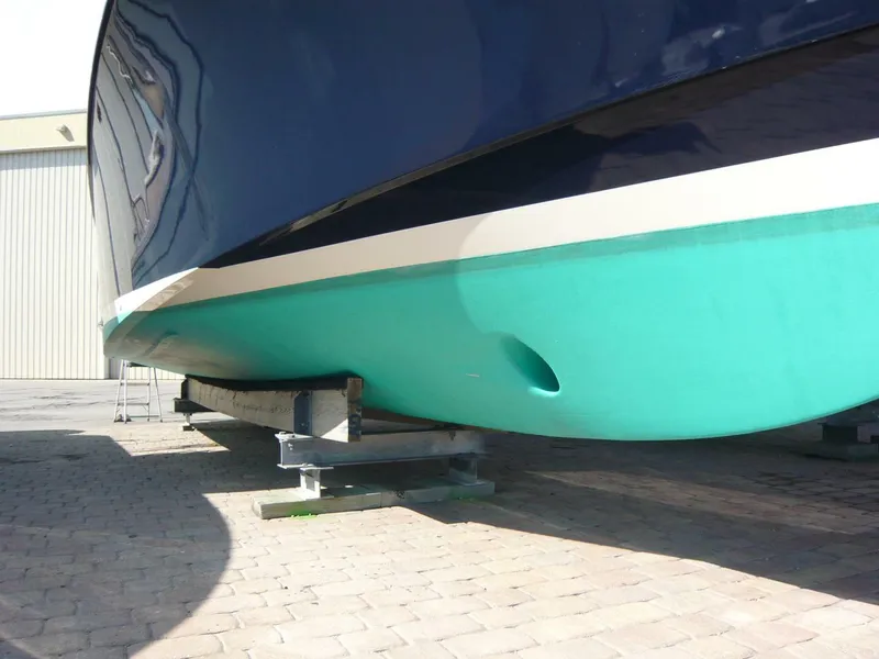 Slide: The Image of Hinckley 36 Classic 1998 boat hull on dry dock, showing turquoise and navy colors. - 33