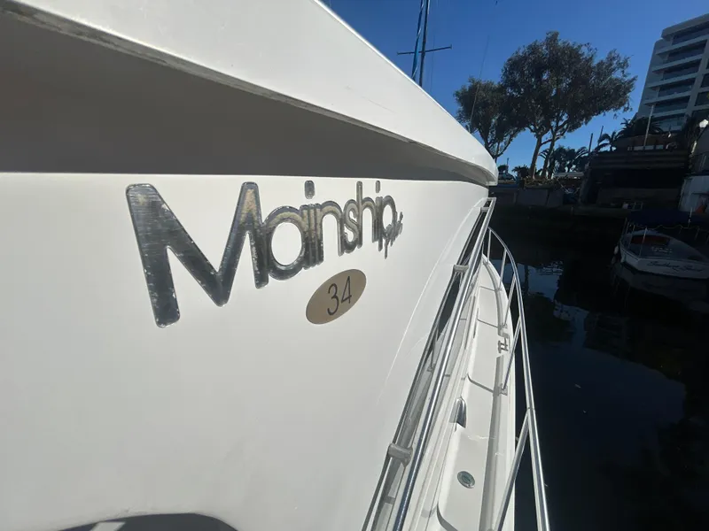 Slide: The Image of 2000 Mainship Pilot 34 boat docked, showcasing brand logo and model number. - 2
