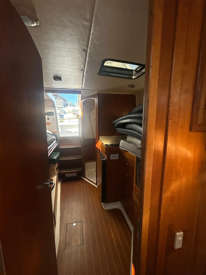 Slide: The Image of Interior view of 2000 Mainship Pilot 34 boat with wooden finishes and natural light. - 24
