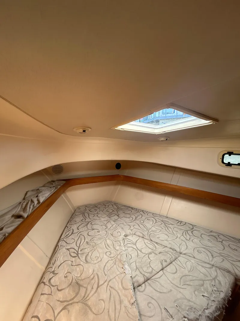 Slide: The Image of Interior cabin of 2000 Mainship Pilot 34 with skylight and patterned bedding. - 25