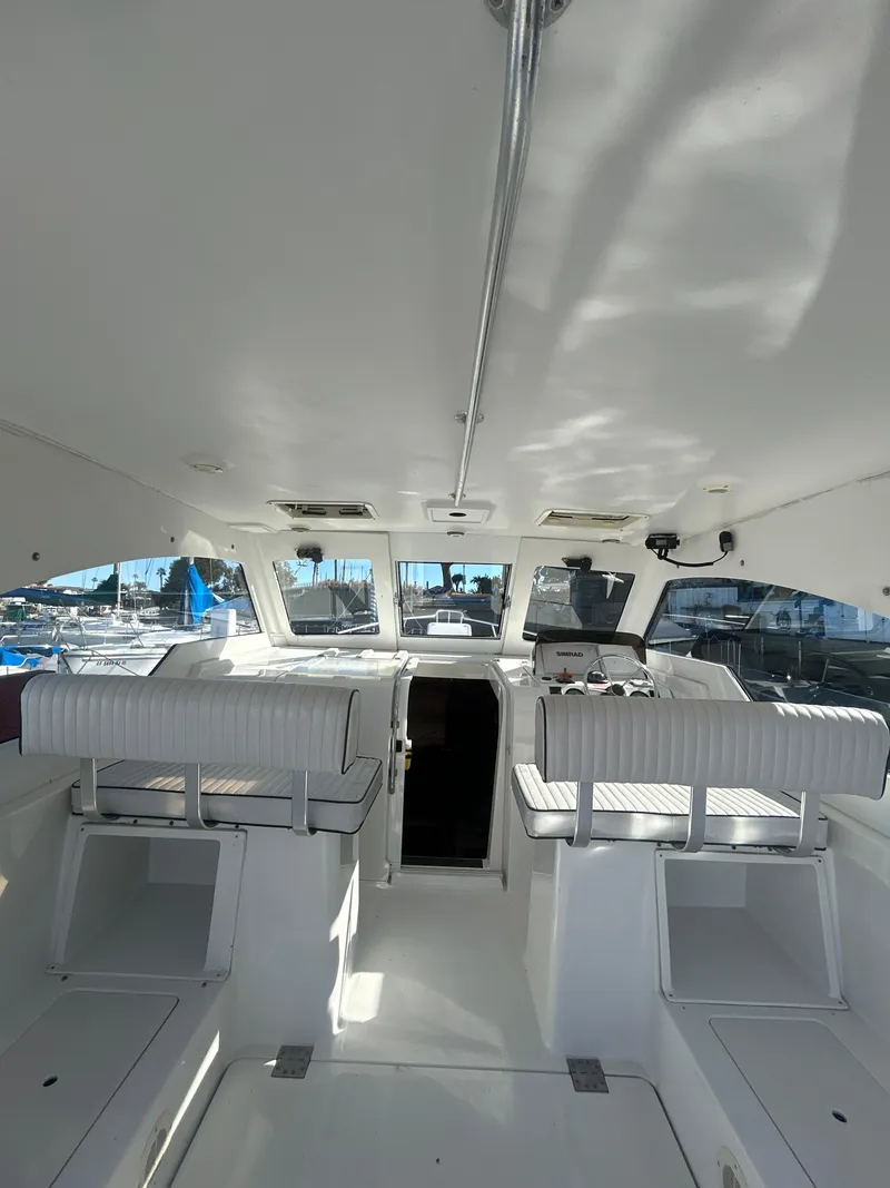 Slide: The Image of 2000 Mainship Pilot 34 interior with white seating and helm, showcasing spacious design. - 31