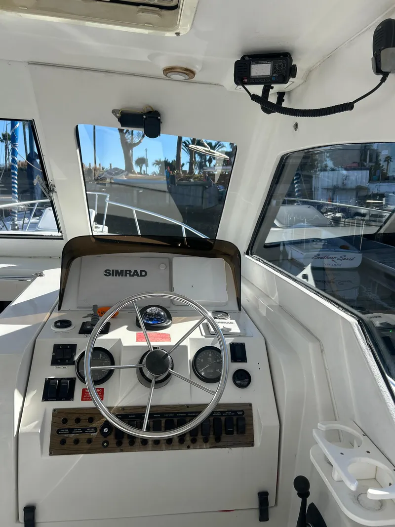 Slide: The Image of 2000 Mainship Pilot 34 boat cockpit with steering wheel and navigation equipment. - 32