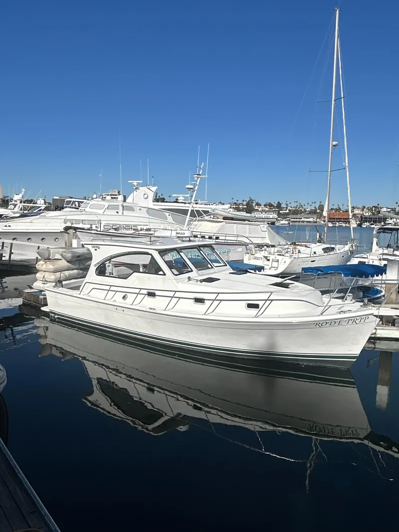 Slide: The Image of 2000 Mainship Pilot 34 yacht docked in a marina under clear blue skies. - 5