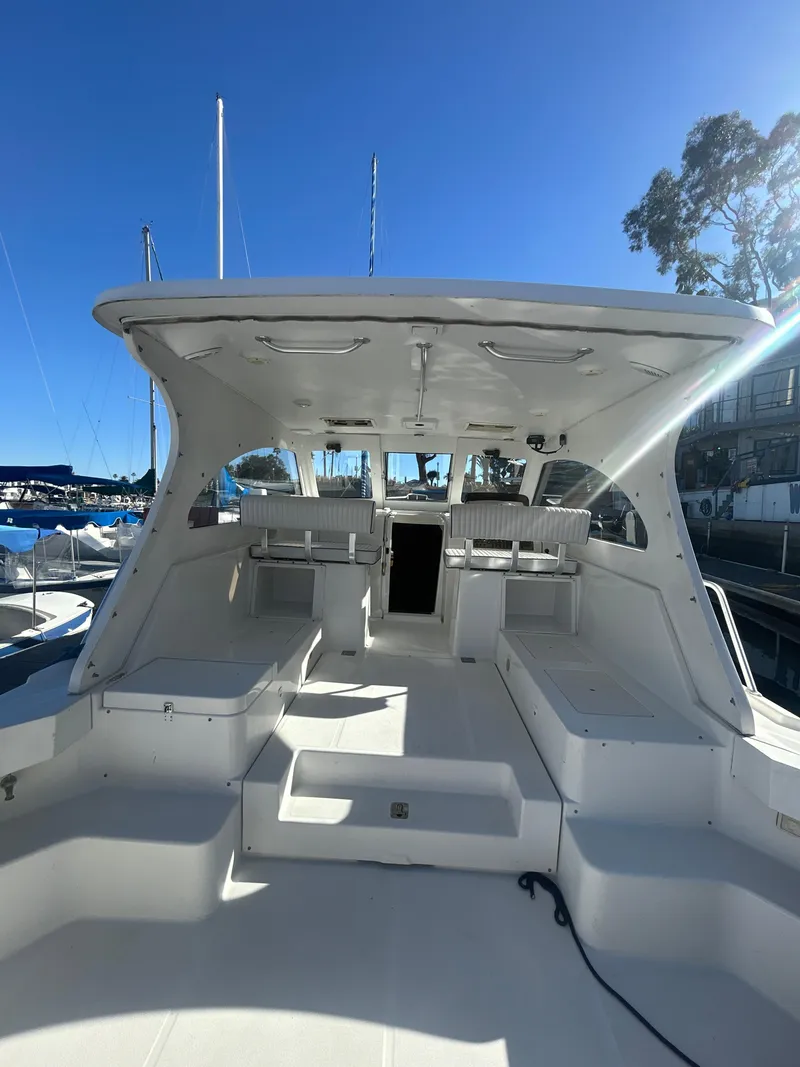 Slide: The Image of 2000 Mainship Pilot 34 boat interior with seating, docked under clear blue sky. - 6