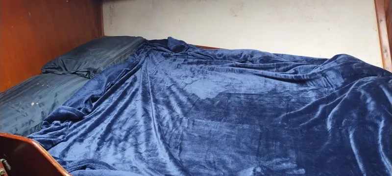 Slide: The Image of Kabine mit einem großen Bett, bedeckt mit einer blauen Decke, in einem Island Trader Motorsegler. - 32