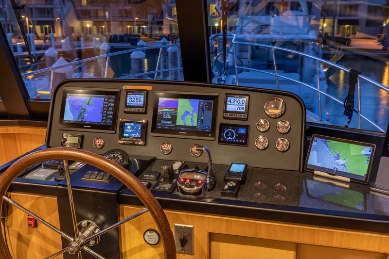 Slide: The Image of North Pacific 49 Euro Pilothouse 2021 helm with navigation displays and controls at marina. - 12