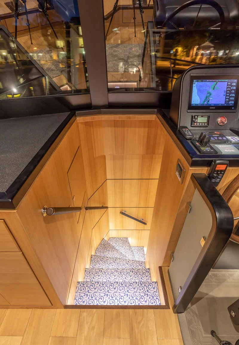 Slide: The Image of Interior of 2021 North Pacific 49 Euro Pilothouse with wooden stairs and navigation controls. - 15