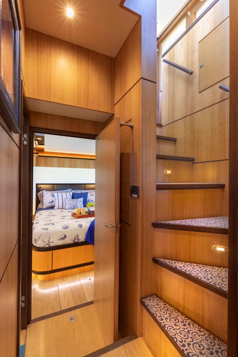 Slide: The Image of Luxurious interior of 2021 North Pacific 49 Euro Pilothouse yacht with wooden stairs and cozy bedroom. - 16