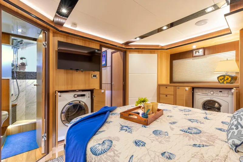 Slide: The Image of Luxurious 2021 North Pacific 49 Euro Pilothouse bedroom with ensuite, washer, and elegant decor. - 19