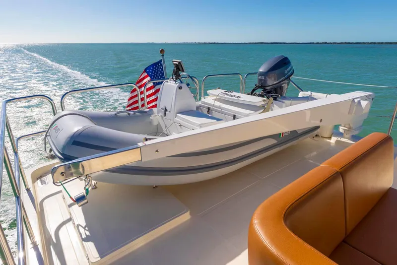 Slide: The Image of 2021 North Pacific 49 Euro Pilothouse yacht with dinghy on deck, cruising in open waters. - 25