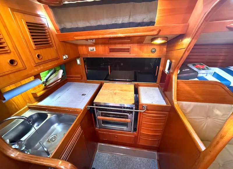 Slide: The Image of Nautor Swan 391 yacht kitchen interior, 1984 model, featuring wood cabinetry and stainless steel sink. - 14