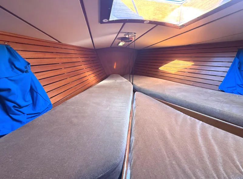 Slide: The Image of Cozy cabin interior of 1984 Nautor Swan 391 sailboat with wooden paneling and blue accents. - 16