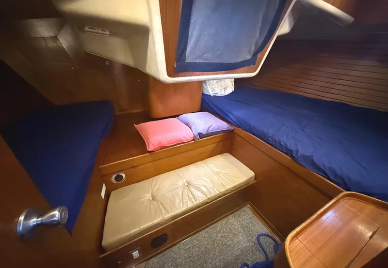 Slide: The Image of Cozy cabin interior of 1984 Nautor Swan 391 sailboat with wooden finishes and blue bedding. - 17