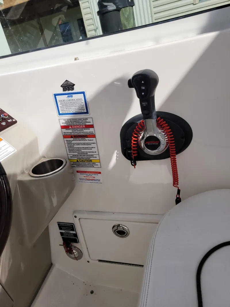 Slide: The Image of 2010 Sea Ray 280 Sundancer boat control panel with throttle and safety features. - 11