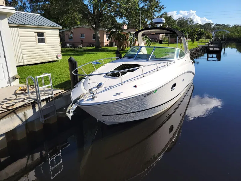 Slide: The Image of 2010 Sea Ray 280 Sundancer docked on a calm canal. - 2