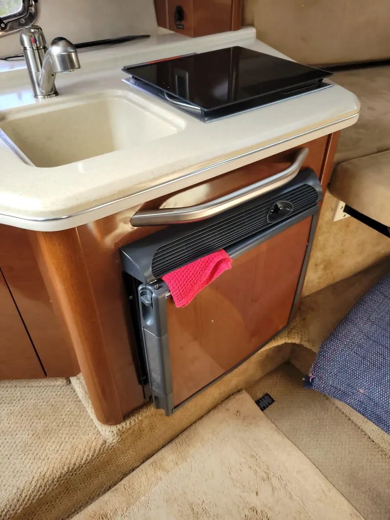 Slide: The Image of 2010 Sea Ray 280 Sundancer cabin with kitchenette and mini fridge. - 22