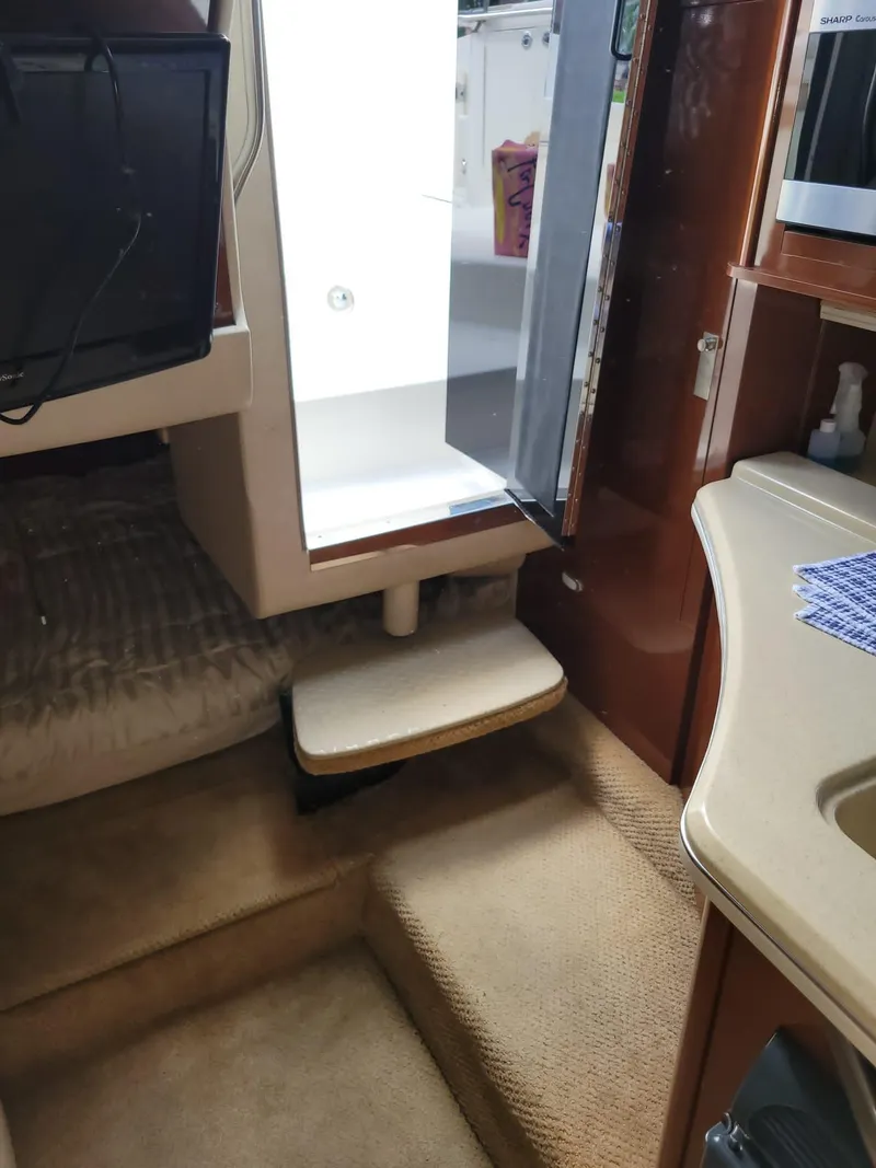 Slide: The Image of Interior of 2010 Sea Ray 280 Sundancer with steps, kitchenette, and open fridge. - 24