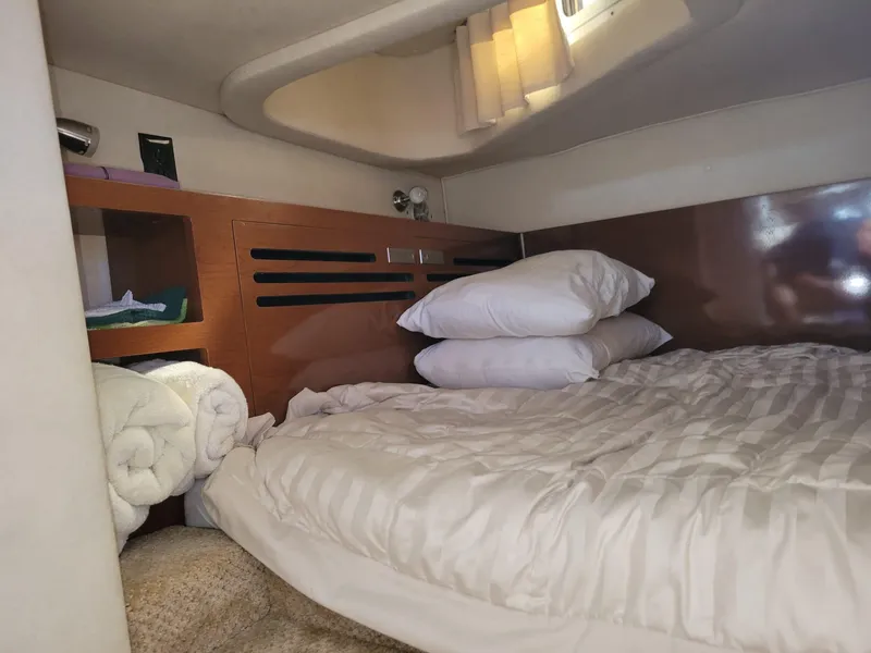 Slide: The Image of Cozy cabin interior of 2010 Sea Ray 280 Sundancer with bed and storage shelves. - 26
