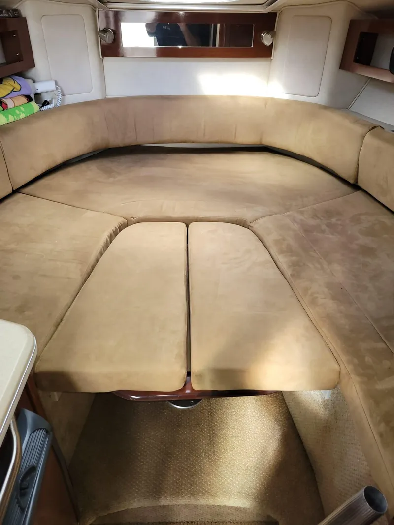 Slide: The Image of 2010 Sea Ray 280 Sundancer interior cabin with beige seating and cozy layout. - 27