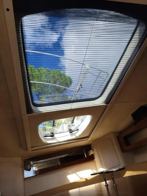 Slide: The Image of Interior view of 2010 Sea Ray 280 Sundancer with skylight and blue sky. - 29