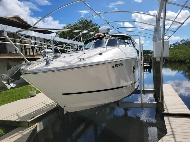Slide: The Image of 2010 Sea Ray 280 Sundancer on a lift by a dock, under a clear blue sky. - 3