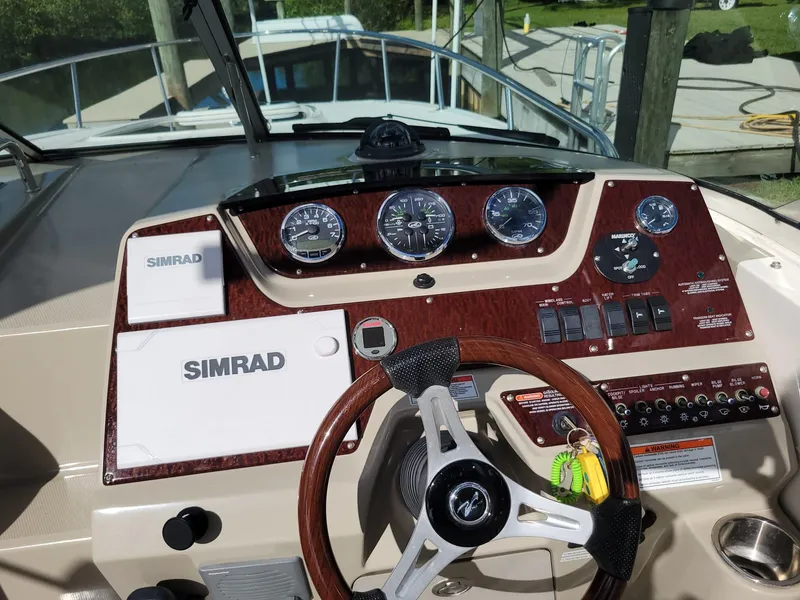 Slide: The Image of 2010 Sea Ray 280 Sundancer dashboard with Simrad navigation system and gauges. - 8