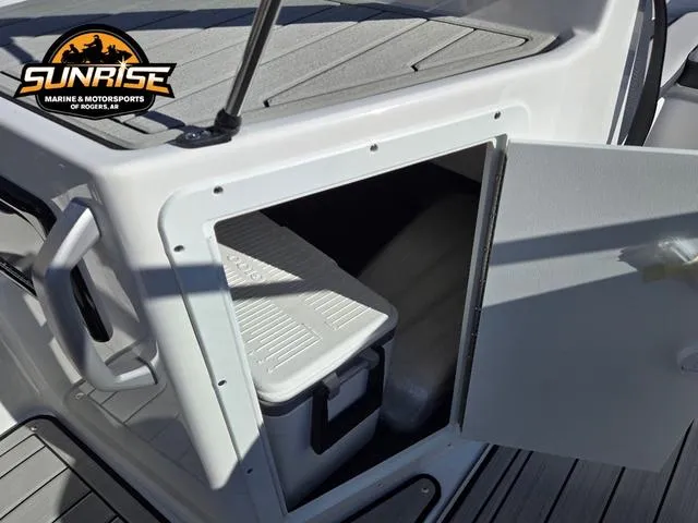 Slide: The Image of 2025 Yamaha Boats 195S storage compartment with cooler, open door, and deck view. - 16