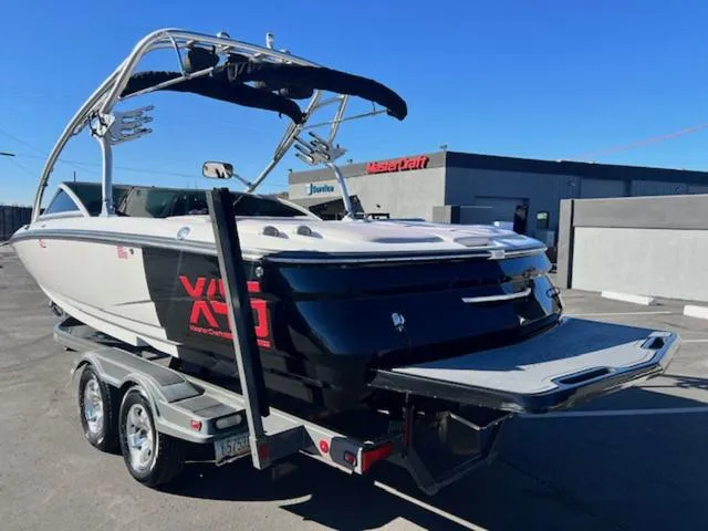 Slide: The Image of 2006 MasterCraft X45 boat on trailer, parked outdoors, with wakeboard tower and swim platform. - 8