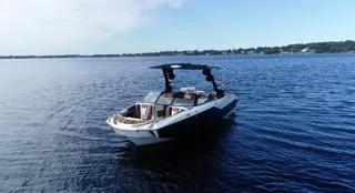 Slide: The Image of 2024 Malibu M242 boat on calm blue water, clear sky background. - 3