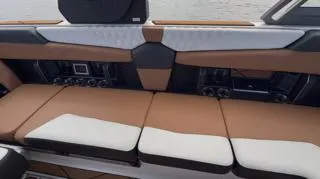 Slide: The Image of 2024 Malibu M242 boat interior with brown and white seating. - 5
