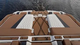 Slide: The Image of 2024 Malibu M242 boat deck with stylish brown and white upholstery on water. - 6
