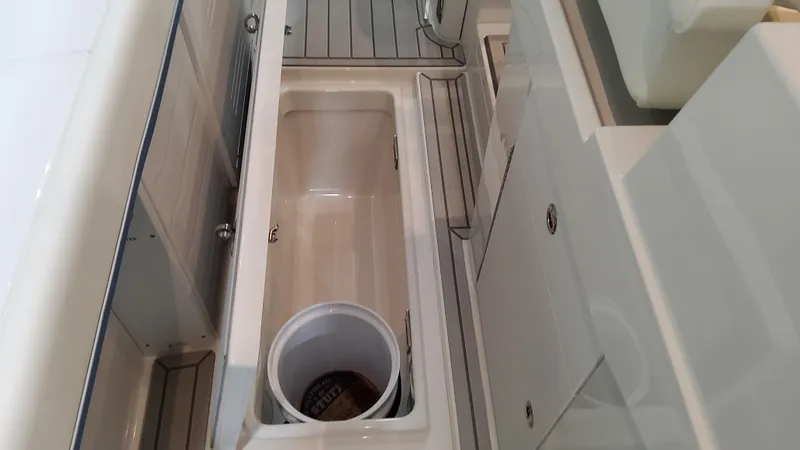 Slide: The Image of 2025 Formula 387 Center Console Fish boat interior with storage compartment and bucket. - 25