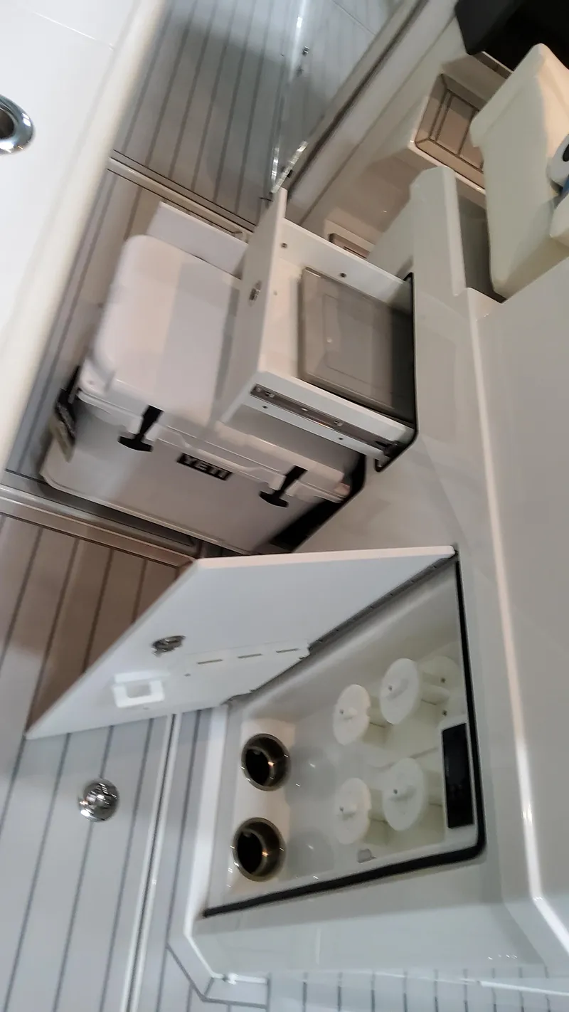 Slide: The Image of 2025 Formula 387 Center Console Fish boat interior with storage compartments and cooler. - 27