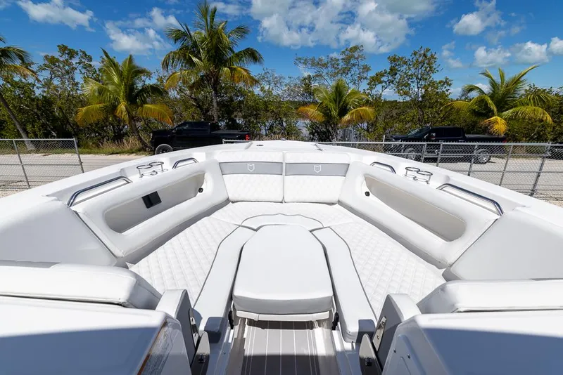 Slide: The Image of 2025 Sea Fox 288 Traveler boat interior with white seating, under a clear blue sky. - 25