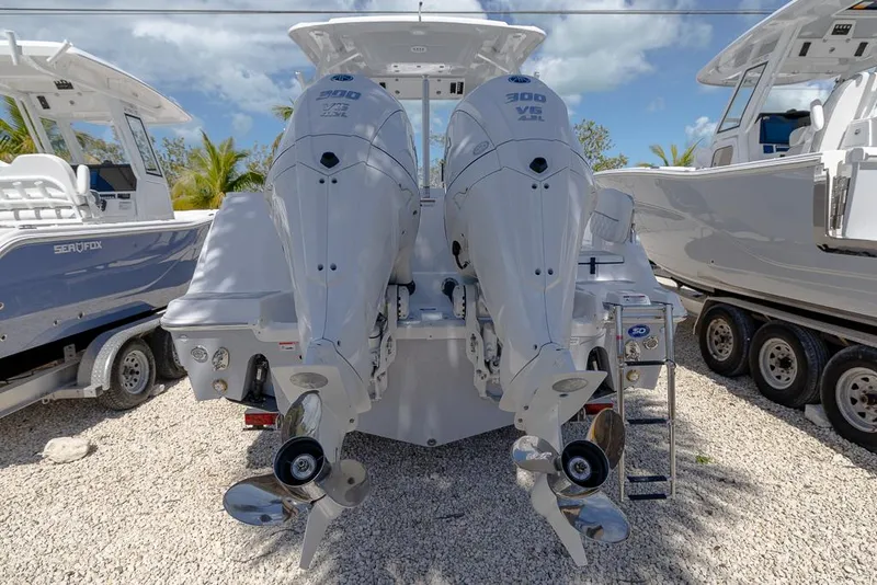 Slide: The Image of 2025 Sea Fox 288 Traveler with dual outboard engines, parked on gravel. - 4