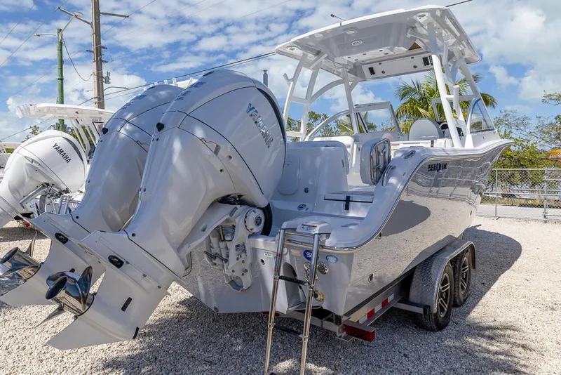 Slide: The Image of 2025 Sea Fox 288 Traveler boat with dual engines on a trailer, parked outdoors. - 5
