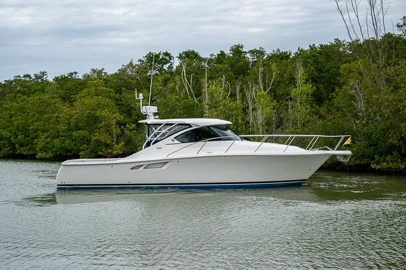 Slide: The Image of 2013 Tiara Yachts 3600 Open cruising on a calm river with lush greenery. - 0