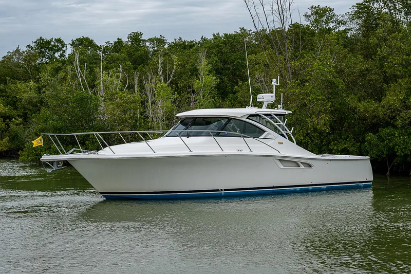 Slide: The Image of 2013 Tiara Yachts 3600 Open cruising on a calm river near lush greenery. - 2