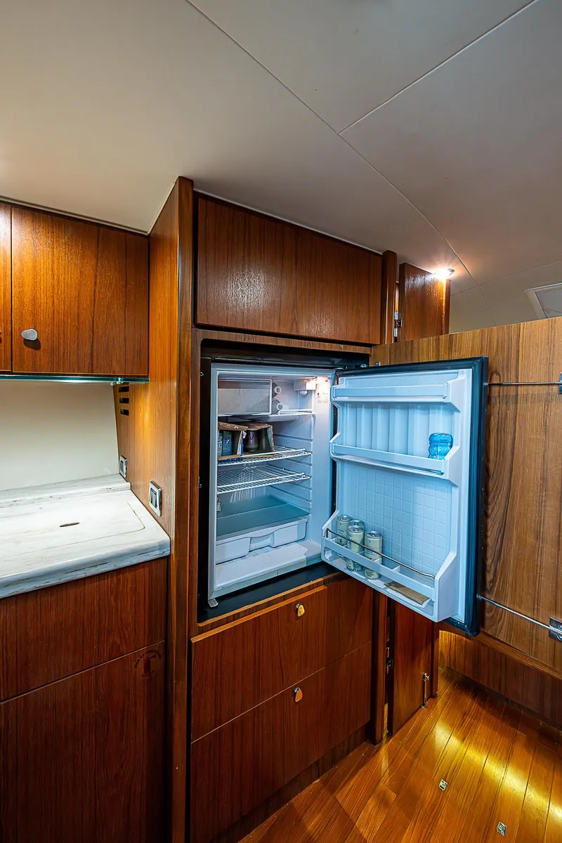 Slide: The Image of 2013 Tiara Yachts 3600 Open interior with open fridge, wooden cabinetry, and sleek design. - 21
