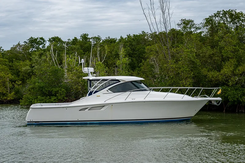Slide: The Image of 2013 Tiara Yachts 3600 Open cruising on a calm river, surrounded by lush greenery. - 27