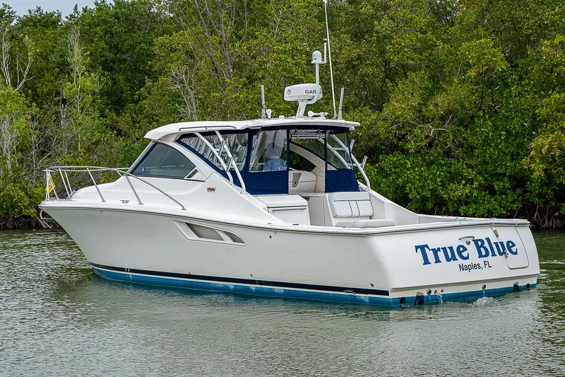 Slide: The Image of 2013 Tiara Yachts 3600 Open boat named "True Blue" on calm water. - 3
