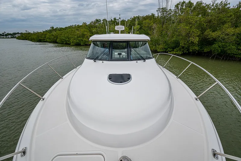 Slide: The Image of 2013 Tiara Yachts 3600 Open on calm water, surrounded by lush greenery. - 6