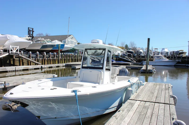 Slide: The Image of 2023 Sea Hunt Gamefish 27 with Coffin Box docked at a marina under clear blue skies. - 13