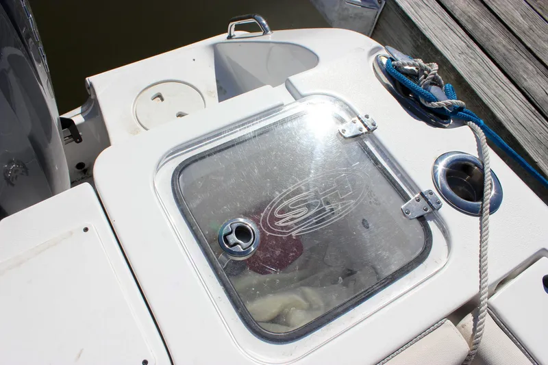 Slide: The Image of 2023 Sea Hunt Gamefish 27 boat deck with transparent storage compartment and rope. - 18