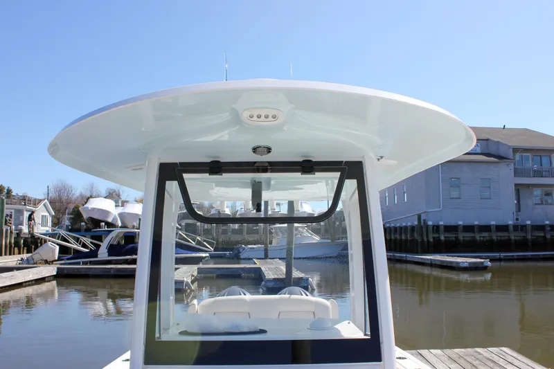 Slide: The Image of 2023 Sea Hunt Gamefish 27 with Coffin Box, docked at a marina under clear skies. - 21
