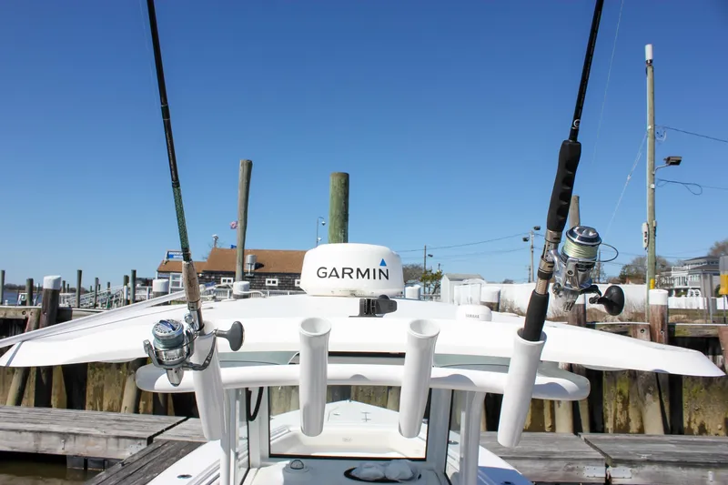 Slide: The Image of 2023 Sea Hunt Gamefish 27 with Coffin Box, featuring fishing rods and Garmin equipment at a dock. - 23