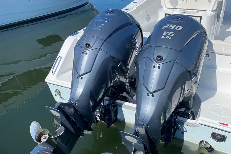 Slide: The Image of 2023 Sea Hunt Gamefish 27 with twin 250 V6 engines, docked in water. - 8