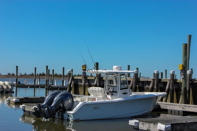 Slide: The Image of 2023 Sea Hunt Gamefish 27 with Coffin Box docked at a marina under clear blue skies. - 9