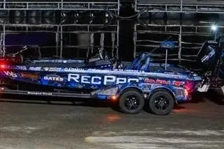 The Image of 2025 Ranger Z520 boat with vibrant graphics on a trailer in a dimly lit setting. - 85