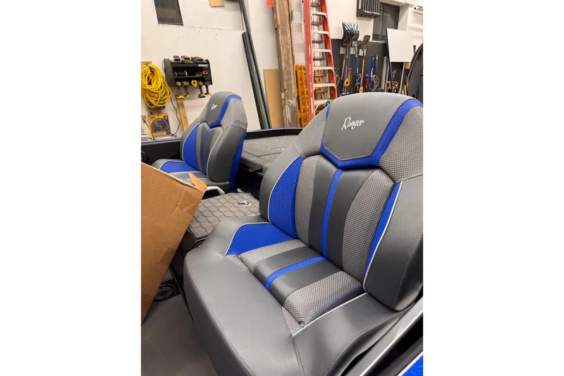Slide: The Image of 2025 Ranger Z520 boat seats in workshop, featuring blue and gray upholstery. - 87